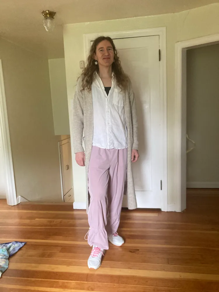 Amber with long hair, pink pants, and pink and white shoes.